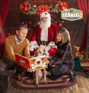 Dog mom and dad reading to their pup with Santa